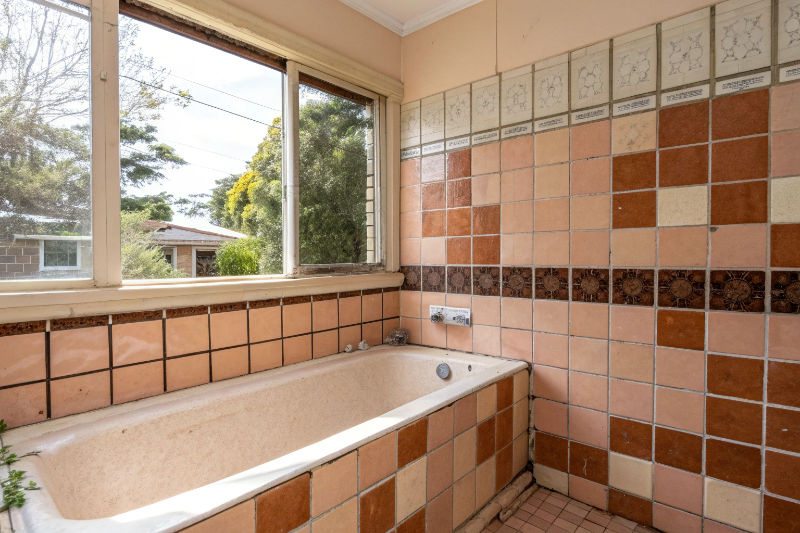Dated 1970s peach and brown bathroom tiles in older Wallsend home